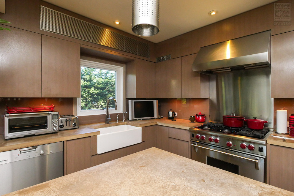 Photo of a mid-sized l-shaped eat-in kitchen in Newark with a farmhouse sink, flat-panel cabinets, medium wood cabinets, soapstone benchtops, beige splashback, stainless steel appliances, with island and beige benchtop.