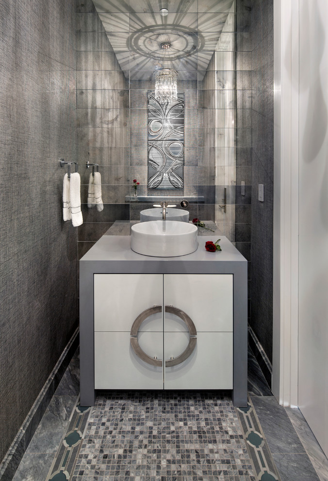 Photo of a small contemporary powder room in San Francisco with flat-panel cabinets, white cabinets, multi-coloured tile, mirror tile, grey walls, mosaic tile floors, a vessel sink, solid surface benchtops and grey floor.