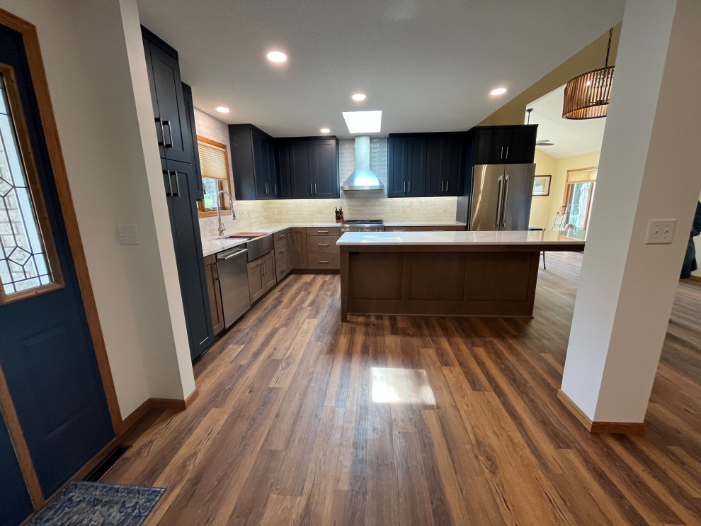 Large transitional l-shaped eat-in kitchen photo with shaker cabinets, quartz countertops and an island