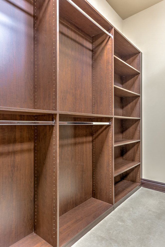 Design ideas for an expansive contemporary gender-neutral walk-in wardrobe in Omaha with recessed-panel cabinets, medium wood cabinets and porcelain floors.