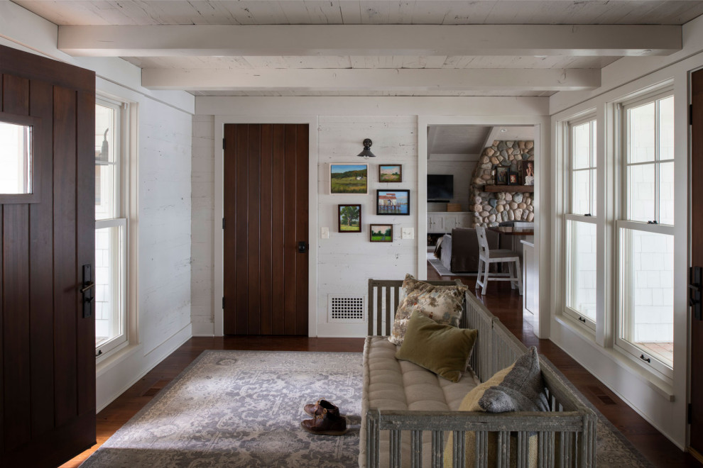 Example of a mid-sized beach style medium tone wood floor, wood ceiling and wood wall single front door design in Minneapolis with white walls and a dark wood front door