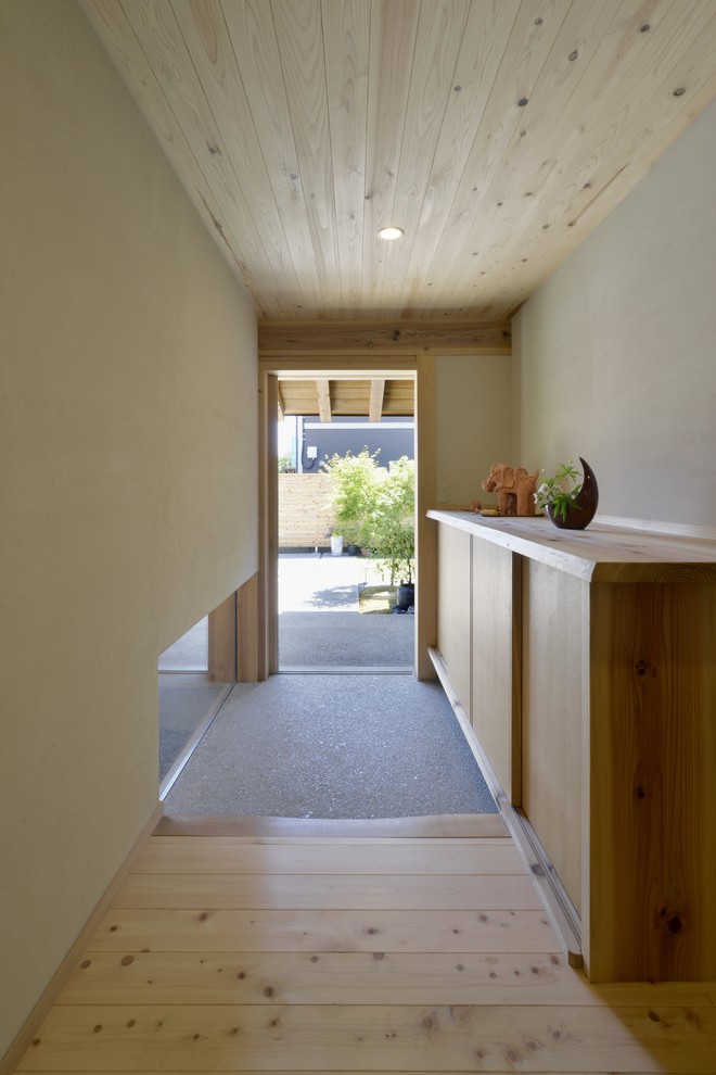 This is an example of an asian entry hall in Other with white walls.