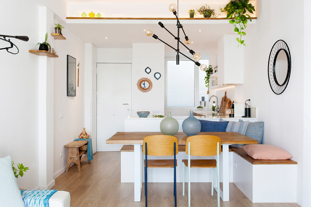 Small contemporary open plan dining in Barcelona with light hardwood floors, brown floor and white walls.