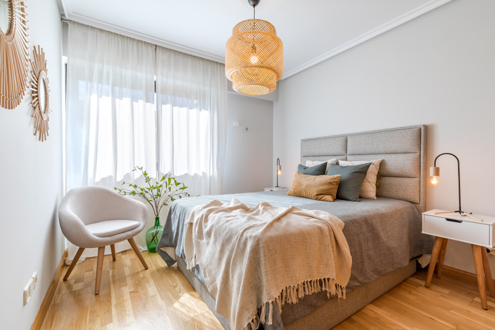Foto de habitación de invitados gris y blanca escandinava de tamaño medio con paredes grises, suelo de madera en tonos medios y suelo marrón
