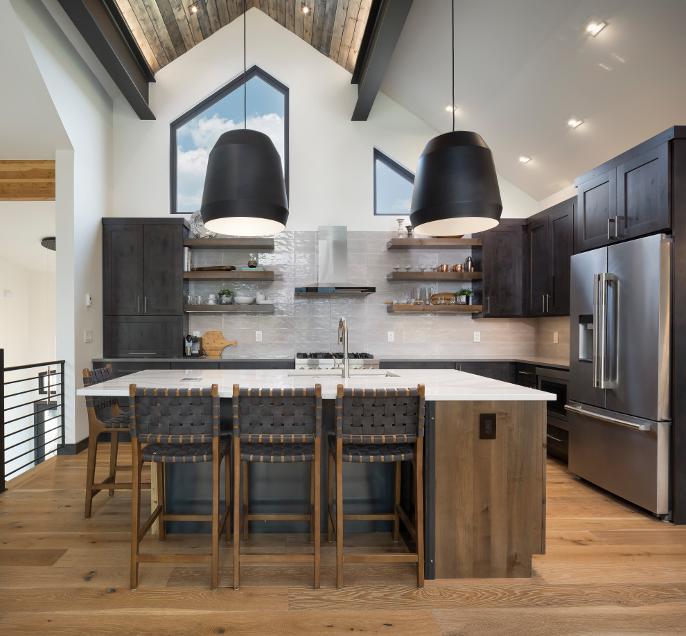 Inspiration for a mid-sized transitional l-shaped light wood floor, shiplap ceiling and brown floor open concept kitchen remodel in Denver with shaker cabinets, gray cabinets, white backsplash, stainless steel appliances, an island, white countertops, an undermount sink and marble countertops