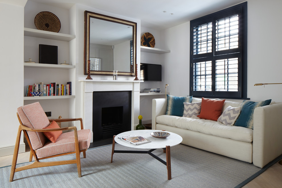Inspiration for a small transitional open concept living room in London with a library, white walls, carpet, a standard fireplace and a metal fireplace surround.