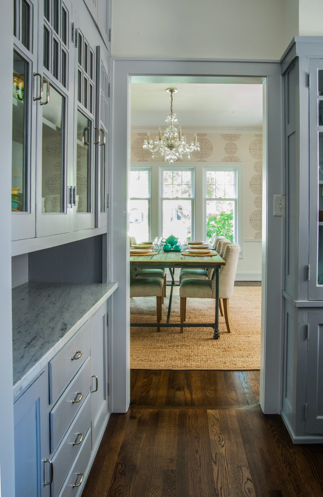 Inspiration for a traditional galley kitchen pantry in Milwaukee with glass-front cabinets, grey cabinets, marble benchtops and dark hardwood floors.