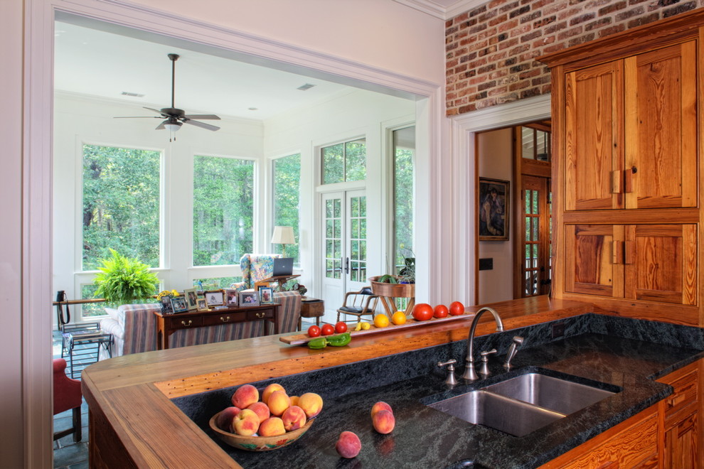 This is an example of a country kitchen in Other with recessed-panel cabinets and medium wood cabinets.