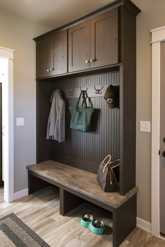 Design ideas for a mid-sized transitional mudroom in Miami with beige walls, laminate floors and brown floor.