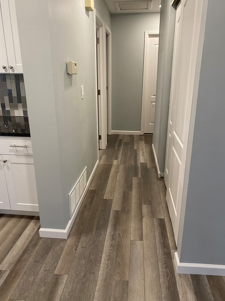 Inspiration for a large transitional l-shaped vinyl floor and gray floor open concept kitchen remodel in Cincinnati with an undermount sink, raised-panel cabinets, white cabinets, granite countertops, multicolored backsplash, ceramic backsplash, stainless steel appliances, an island and black countertops