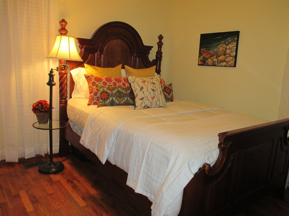 Photo of a mid-sized traditional guest bedroom in Cincinnati with yellow walls and dark hardwood floors.