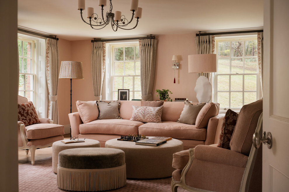 Traditional enclosed living room in London with pink walls, medium hardwood flooring and brown floors.