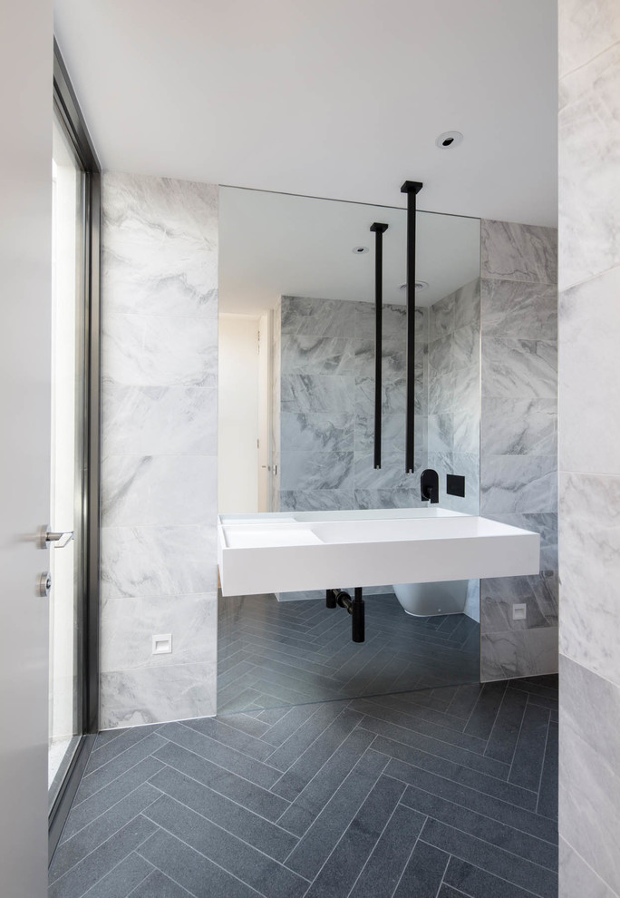 Contemporary bathroom in Melbourne with a wall-mount sink and black floor.