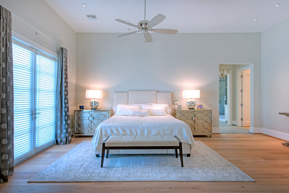 Photo of a large contemporary master bedroom in Phoenix with beige walls and light hardwood floors.