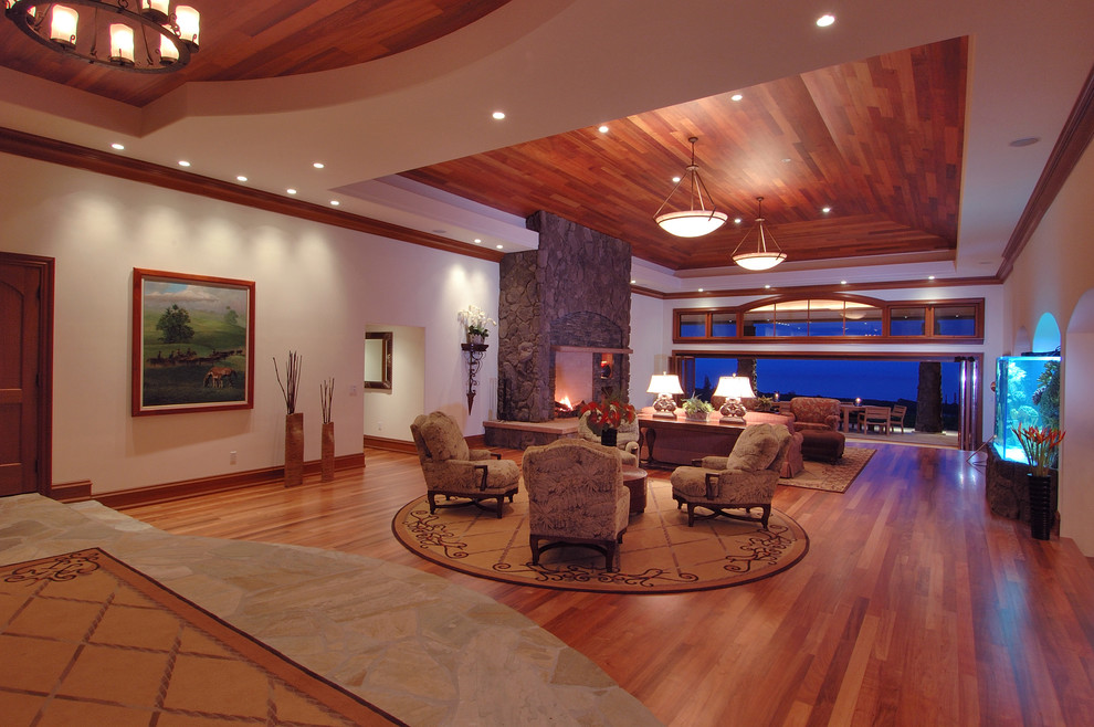 Large contemporary formal open concept living room in Hawaii with a stone fireplace surround, white walls, medium hardwood floors, a standard fireplace, no tv and brown floor.