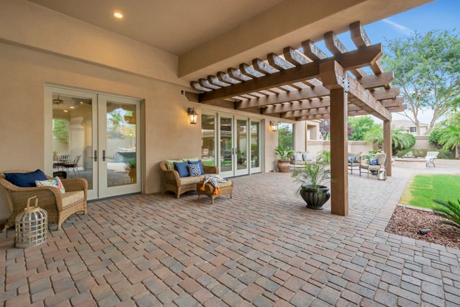 Example of a large transitional backyard concrete paver patio design in Phoenix with a fire pit and a pergola