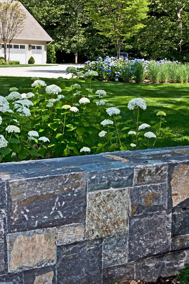 Inspiration for a large traditional front yard driveway in New York with natural stone pavers.