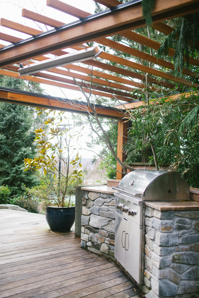 Photo of a small transitional backyard patio in Seattle with an outdoor kitchen, decking and a pergola.
