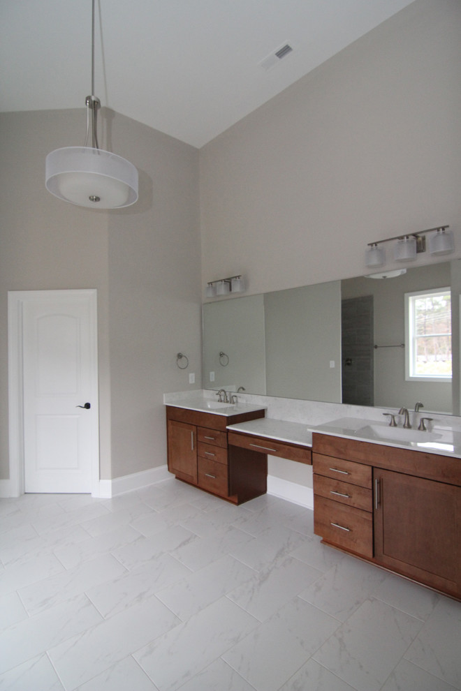 This is an example of a large contemporary master bathroom in Raleigh with shaker cabinets, medium wood cabinets, an open shower, a one-piece toilet, white tile, ceramic tile, grey walls, ceramic floors, an integrated sink and solid surface benchtops.