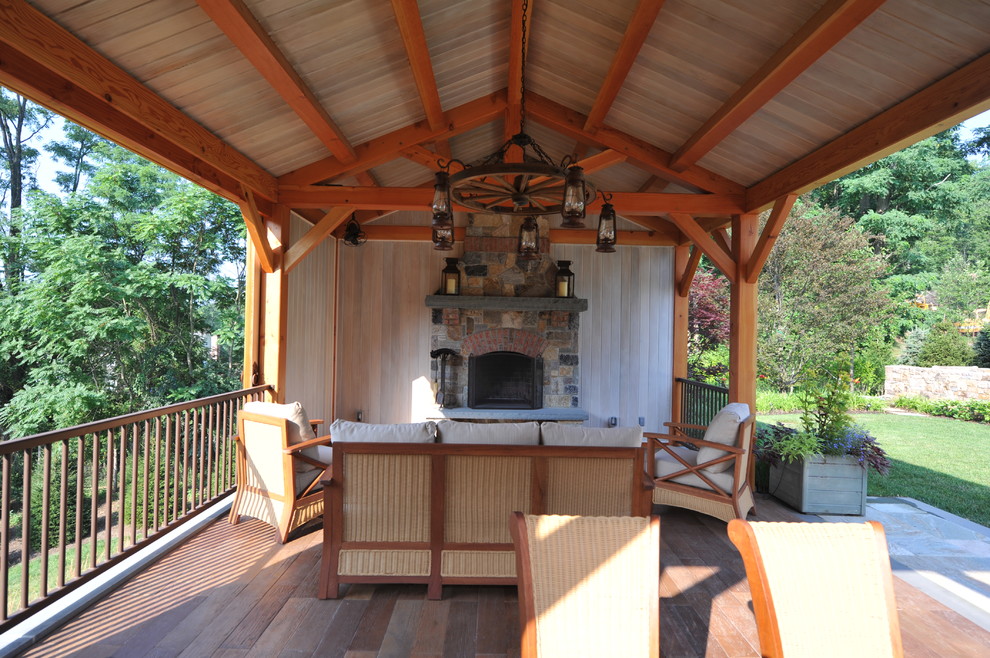 This is an example of a mid-sized traditional backyard patio in New York with a fire feature, decking and a gazebo/cabana.