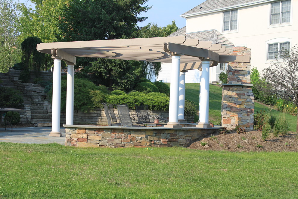 This is an example of a mid-sized transitional full sun backyard stone landscaping in Chicago for spring.