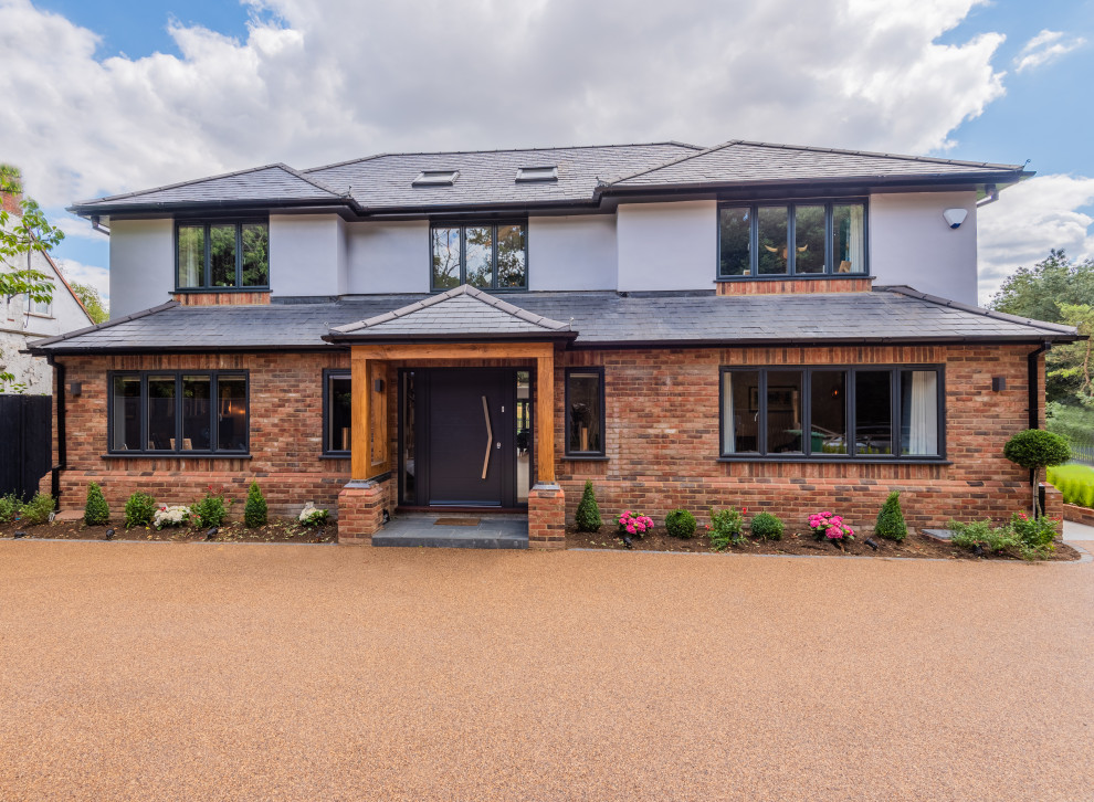This is an example of a large eclectic two-storey brick white house exterior in Hertfordshire with a hip roof, a tile roof and a grey roof.