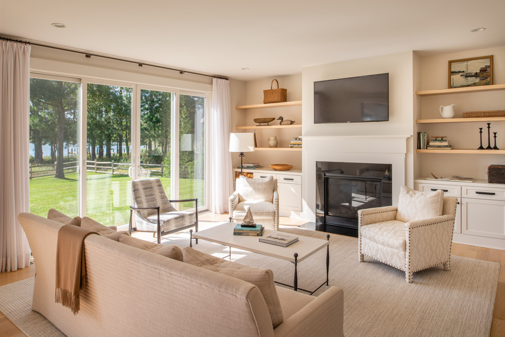 Example of a large farmhouse open concept light wood floor and brown floor living room design in Baltimore with beige walls, a standard fireplace, a metal fireplace and a wall-mounted tv