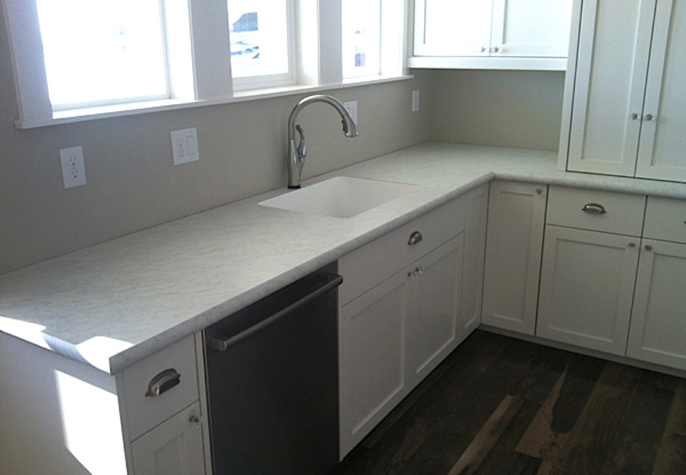 Example of a mid-sized transitional medium tone wood floor and brown floor kitchen design in Boise with an undermount sink, shaker cabinets, white cabinets, laminate countertops, stainless steel appliances and gray countertops