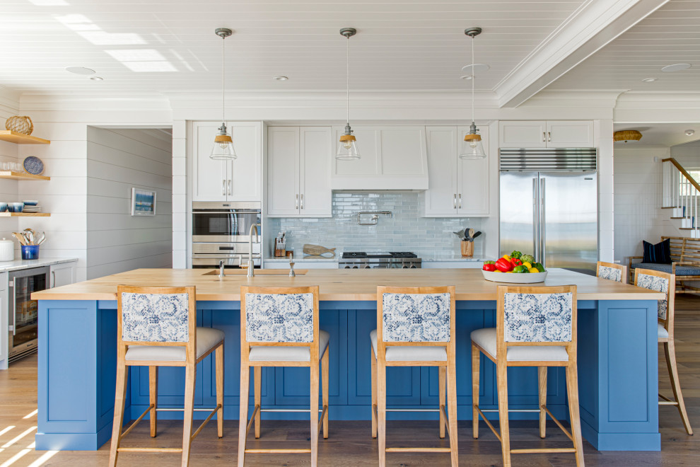 Design ideas for a large beach style l-shaped eat-in kitchen in Boston with a single-bowl sink, white cabinets, granite benchtops, blue splashback, glass tile splashback, stainless steel appliances, with island, white benchtop, timber, shaker cabinets, dark hardwood floors and brown floor.