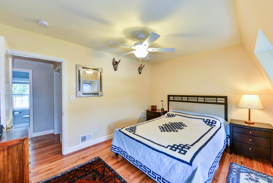 Photo of a small traditional bedroom in DC Metro with yellow walls and medium hardwood floors.