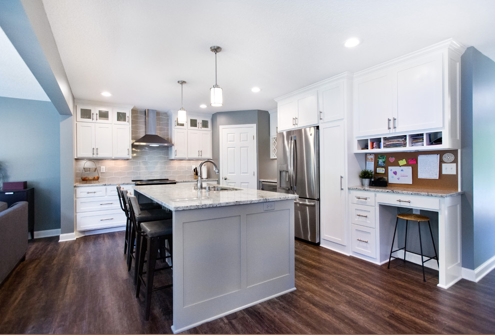 Inspiration for a mid-sized transitional l-shaped vinyl floor and brown floor eat-in kitchen remodel in Minneapolis with an undermount sink, shaker cabinets, white cabinets, granite countertops, gray backsplash, ceramic backsplash, stainless steel appliances, an island and multicolored countertops