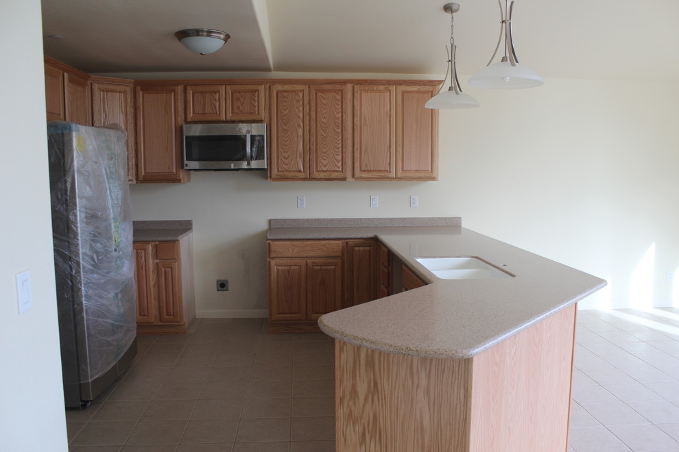 Kitchen - traditional kitchen idea with an integrated sink, raised-panel cabinets and solid surface countertops