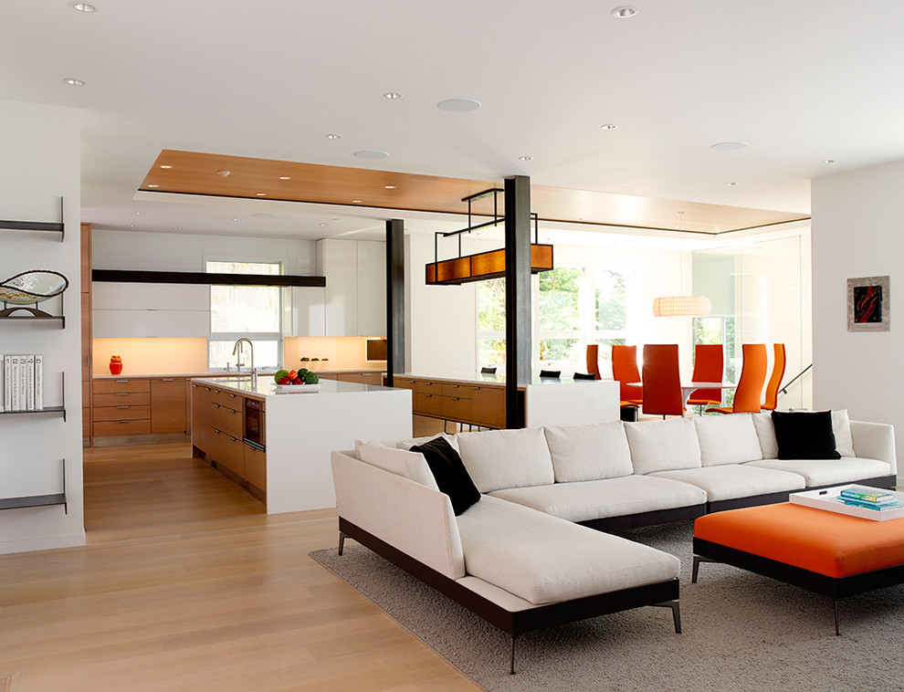 This is an example of a contemporary open concept family room in Seattle with white walls and light hardwood floors.