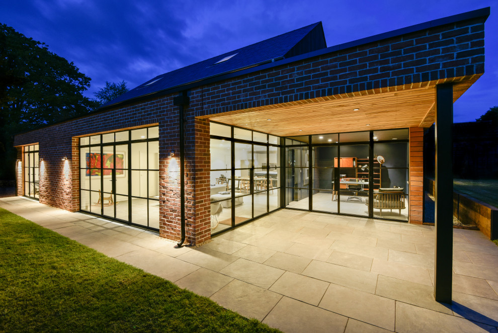 Inspiration for a large contemporary two-storey house exterior in Gloucestershire with wood siding.