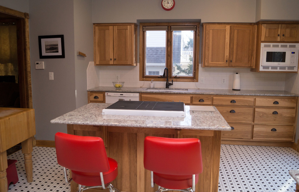 Enclosed kitchen - mid-sized victorian ceramic tile enclosed kitchen idea with an undermount sink, shaker cabinets, light wood cabinets, granite countertops, white backsplash, ceramic backsplash, white appliances and an island