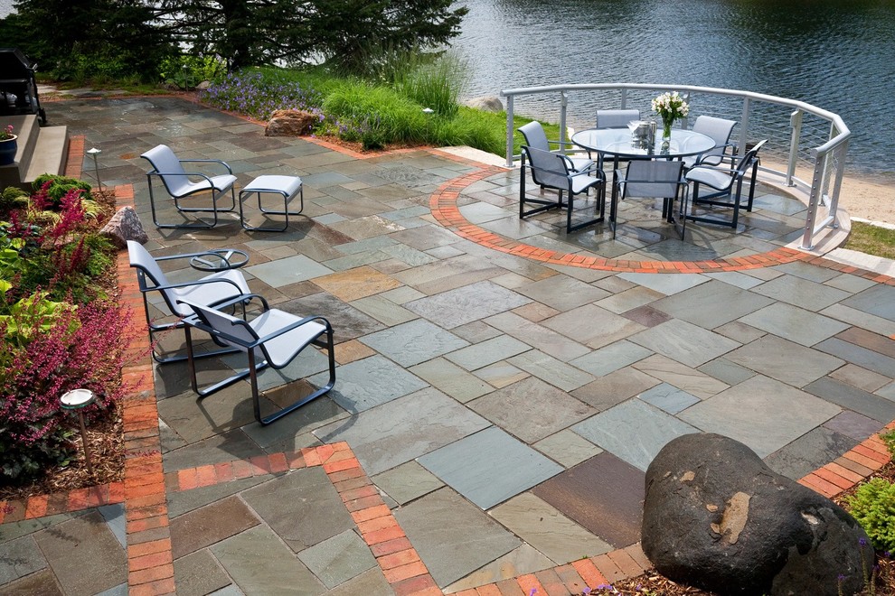 Mid-sized traditional backyard patio in Milwaukee with natural stone pavers.
