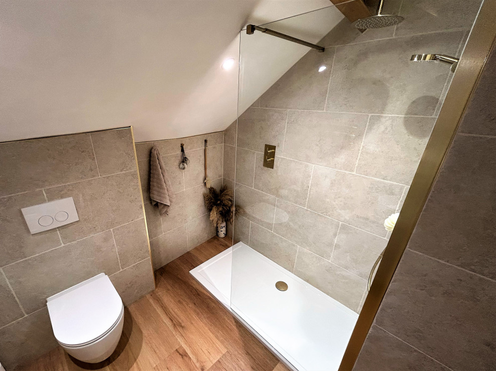 Bild på ett mellanstort funkis badrum för barn, med släta luckor, vita skåp, en öppen dusch, en vägghängd toalettstol, beige kakel, porslinskakel, laminatgolv, ett fristående handfat, träbänkskiva, brunt golv och med dusch som är öppen