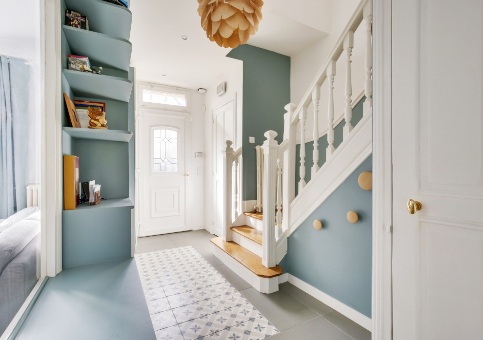 На фото: маленькая узкая прихожая в скандинавском стиле с синими стенами, полом из керамической плитки, одностворчатой входной дверью, белой входной дверью, разноцветным полом и панелями на стенах для на участке и в саду