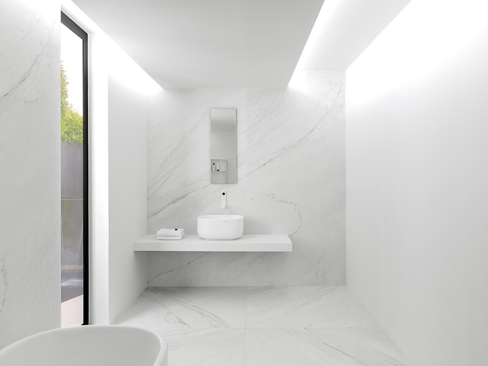 Photo of a contemporary bathroom in Perth with a freestanding tub, white tile, porcelain tile, white walls, porcelain floors, a vessel sink and solid surface benchtops.