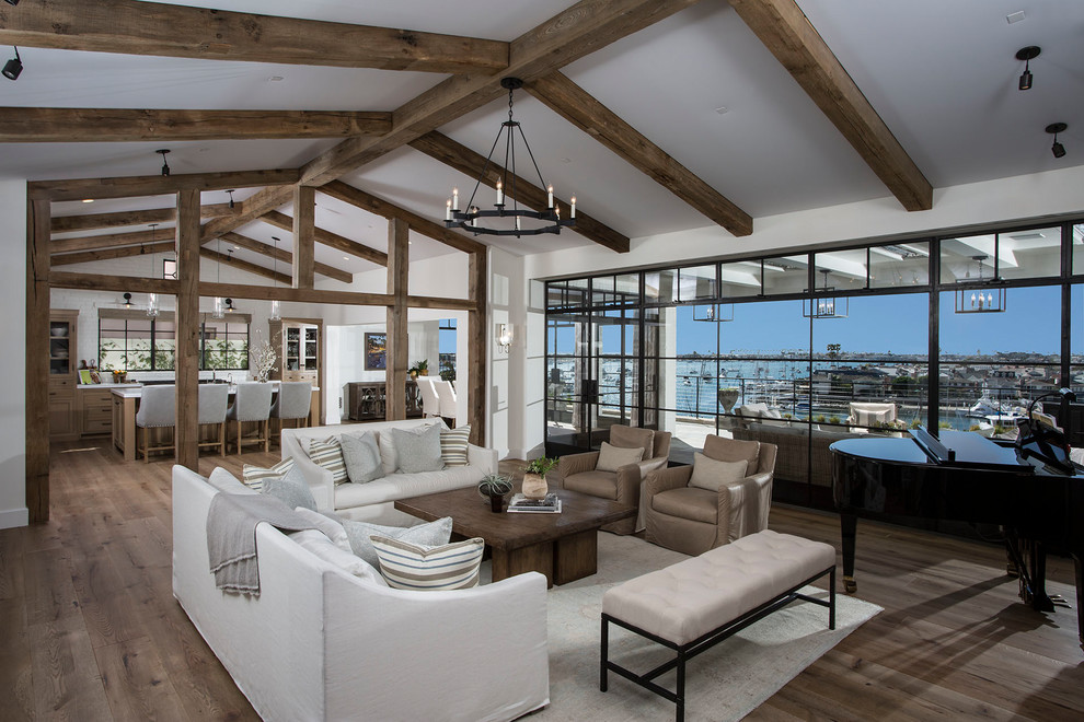 Beach style open concept living room in Orange County with white walls, medium hardwood floors and brown floor.