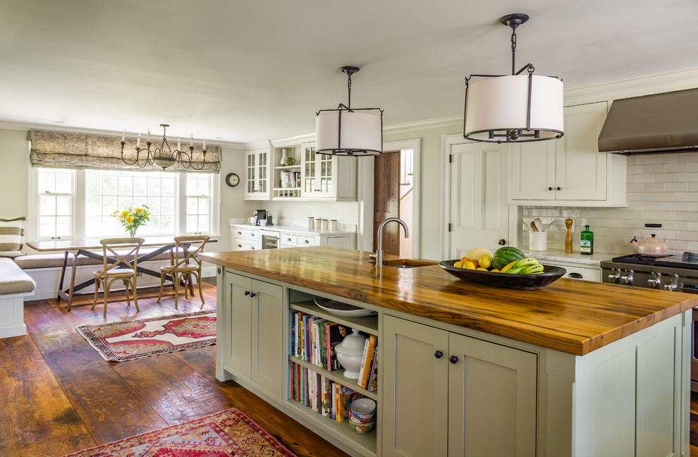 This is an example of a large country l-shaped eat-in kitchen in Boston with a farmhouse sink, recessed-panel cabinets, white cabinets, marble benchtops, white splashback, ceramic splashback, stainless steel appliances, medium hardwood floors and with island.