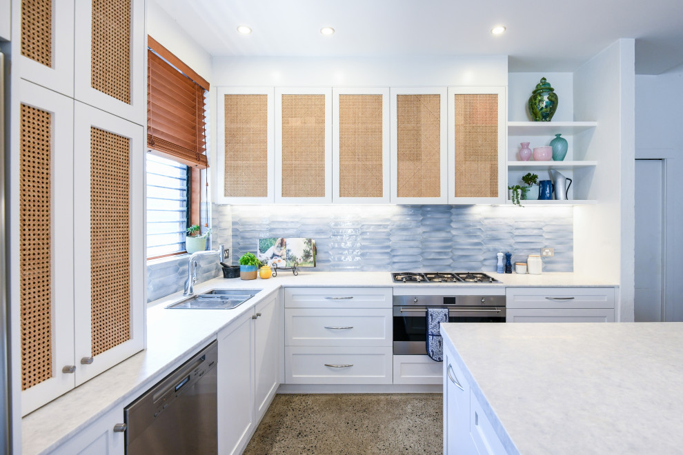 Photo of a large beach style l-shaped open plan kitchen in Sydney with an undermount sink, shaker cabinets, white cabinets, quartzite benchtops, blue splashback, ceramic splashback, stainless steel appliances, concrete floors, with island, grey floor and grey benchtop.