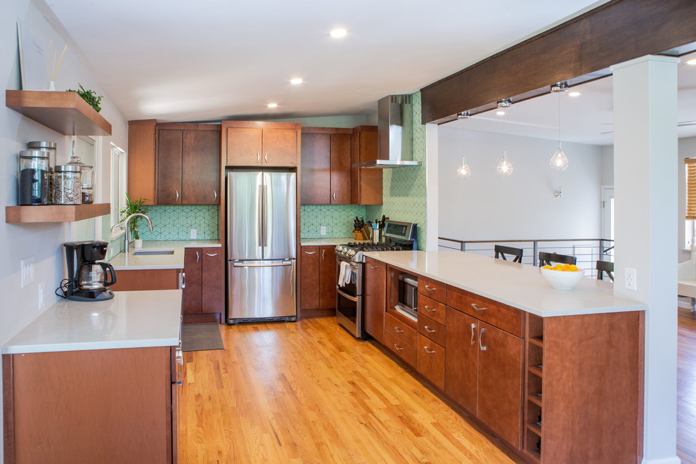 Photo of a mid-sized midcentury u-shaped eat-in kitchen in Denver with an undermount sink, flat-panel cabinets, medium wood cabinets, quartz benchtops, green splashback, ceramic splashback, stainless steel appliances, light hardwood floors, with island, brown floor and white benchtop.