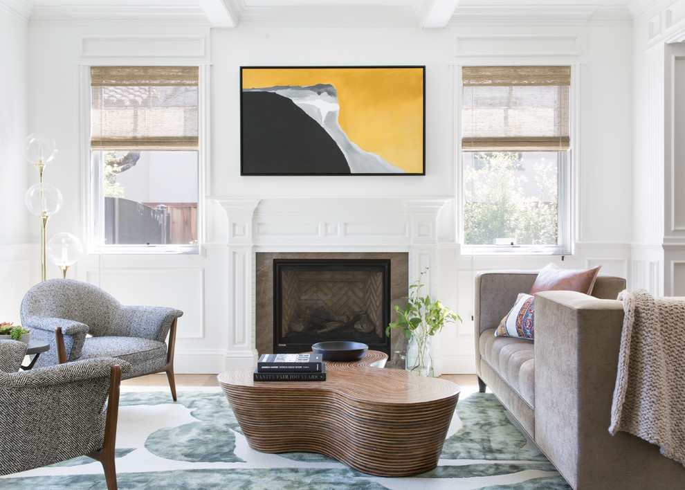 Photo of a transitional enclosed living room in San Francisco with white walls, medium hardwood floors, a standard fireplace and brown floor.