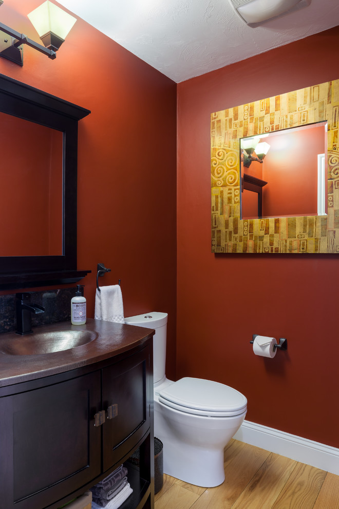 Small traditional kids bathroom in Boston with black cabinets, furniture-like cabinets, a one-piece toilet, red walls, light hardwood floors, brown tile, an integrated sink and solid surface benchtops.