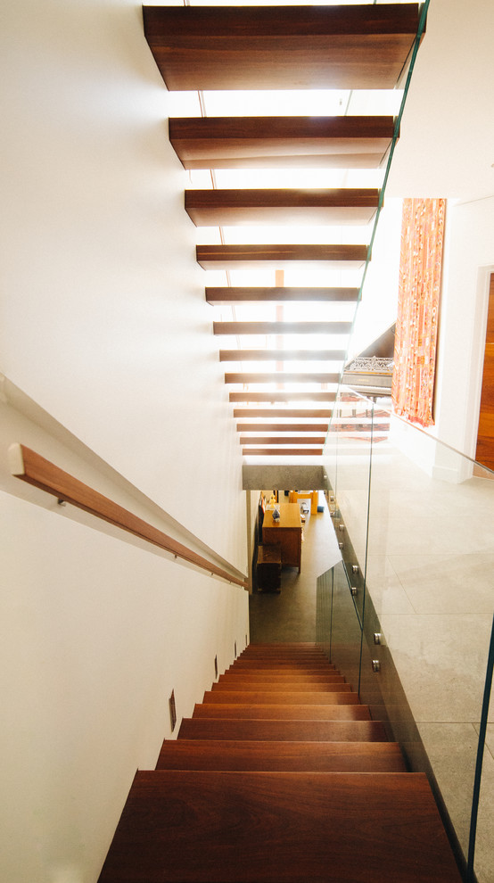 Large contemporary wood floating staircase in Newcastle - Maitland with glass railing.