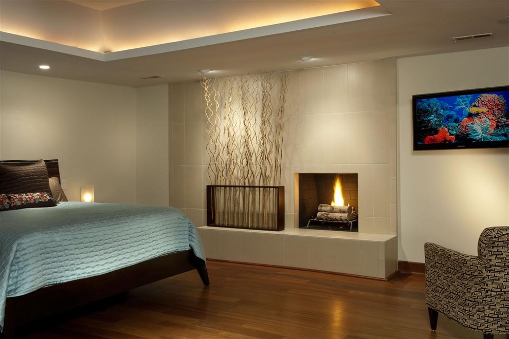 Contemporary bedroom in Other with a tile fireplace surround and a standard fireplace.