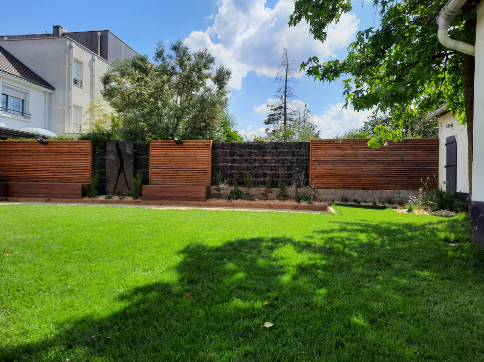 Immagine di un giardino contemporaneo esposto in pieno sole di medie dimensioni e dietro casa in primavera con pedane e recinzione in legno