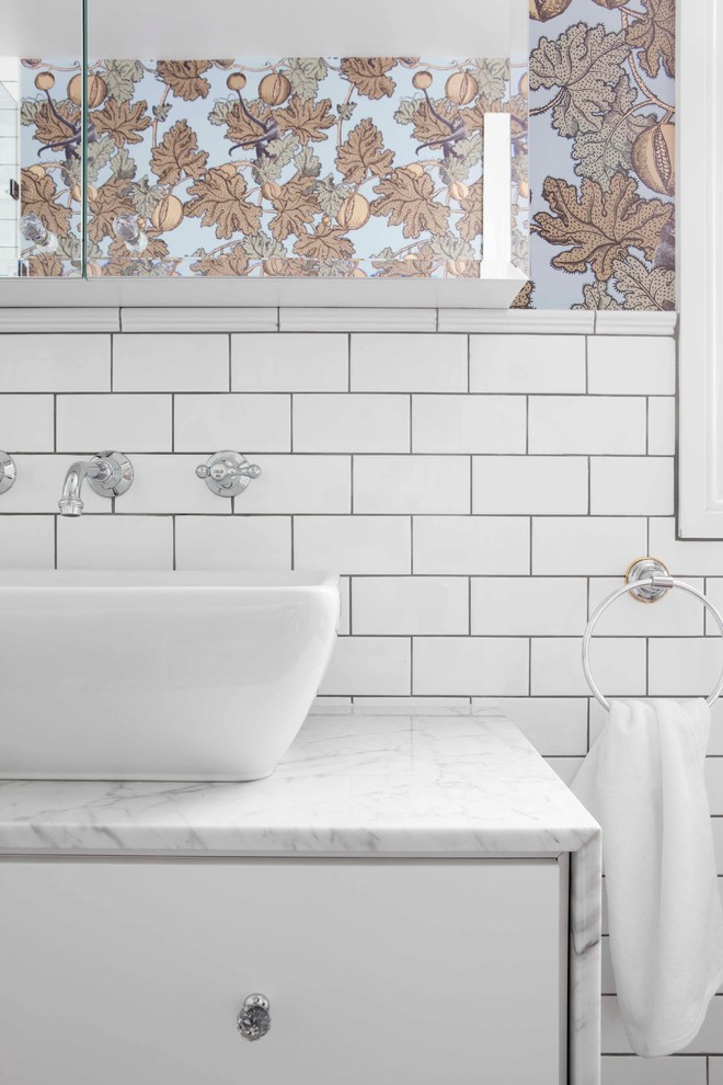 Inspiration for a mid-sized transitional bathroom in Sydney with a vessel sink, flat-panel cabinets, white cabinets, marble benchtops, white tile, subway tile and white walls.