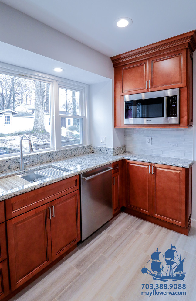 Design ideas for a mid-sized traditional u-shaped eat-in kitchen in DC Metro with an undermount sink, raised-panel cabinets, brown cabinets, quartz benchtops, white splashback, glass tile splashback, stainless steel appliances, ceramic floors, a peninsula, beige floor and multi-coloured benchtop.